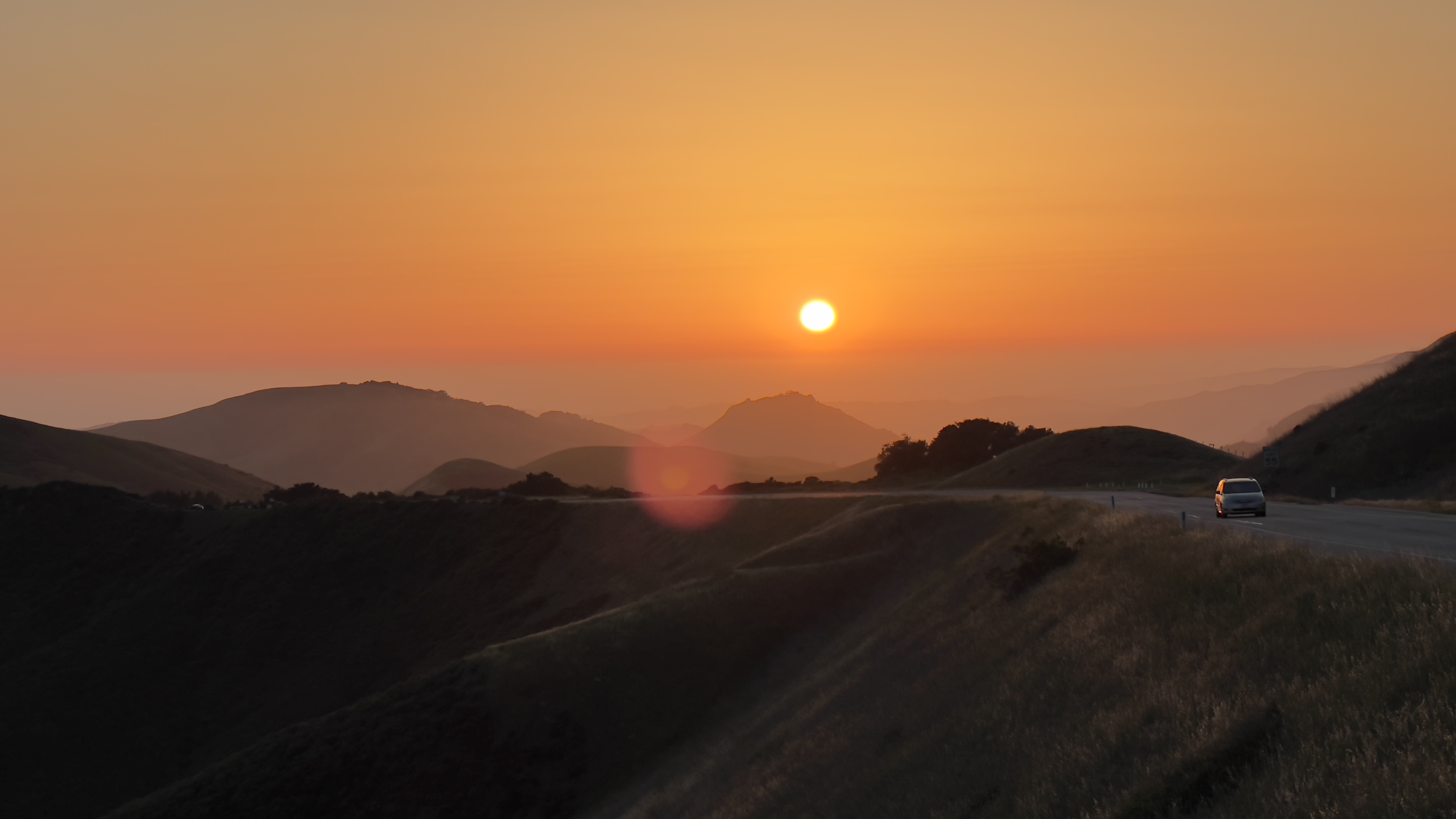 A car on a mountain road at sunset